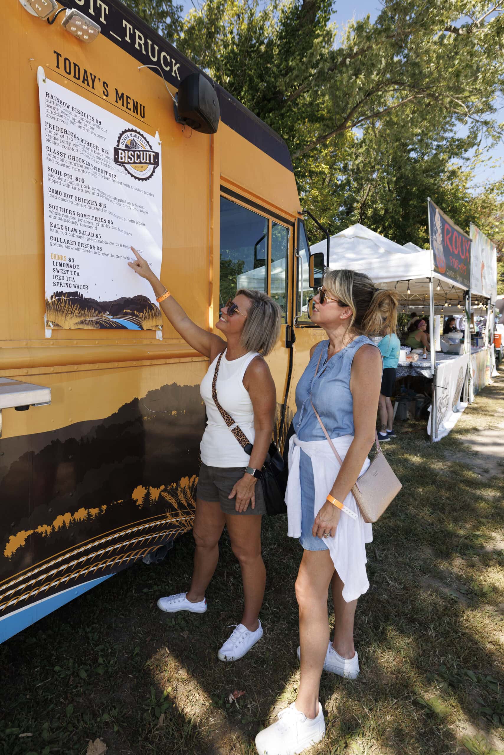 Two women looking at biscuit truck menu