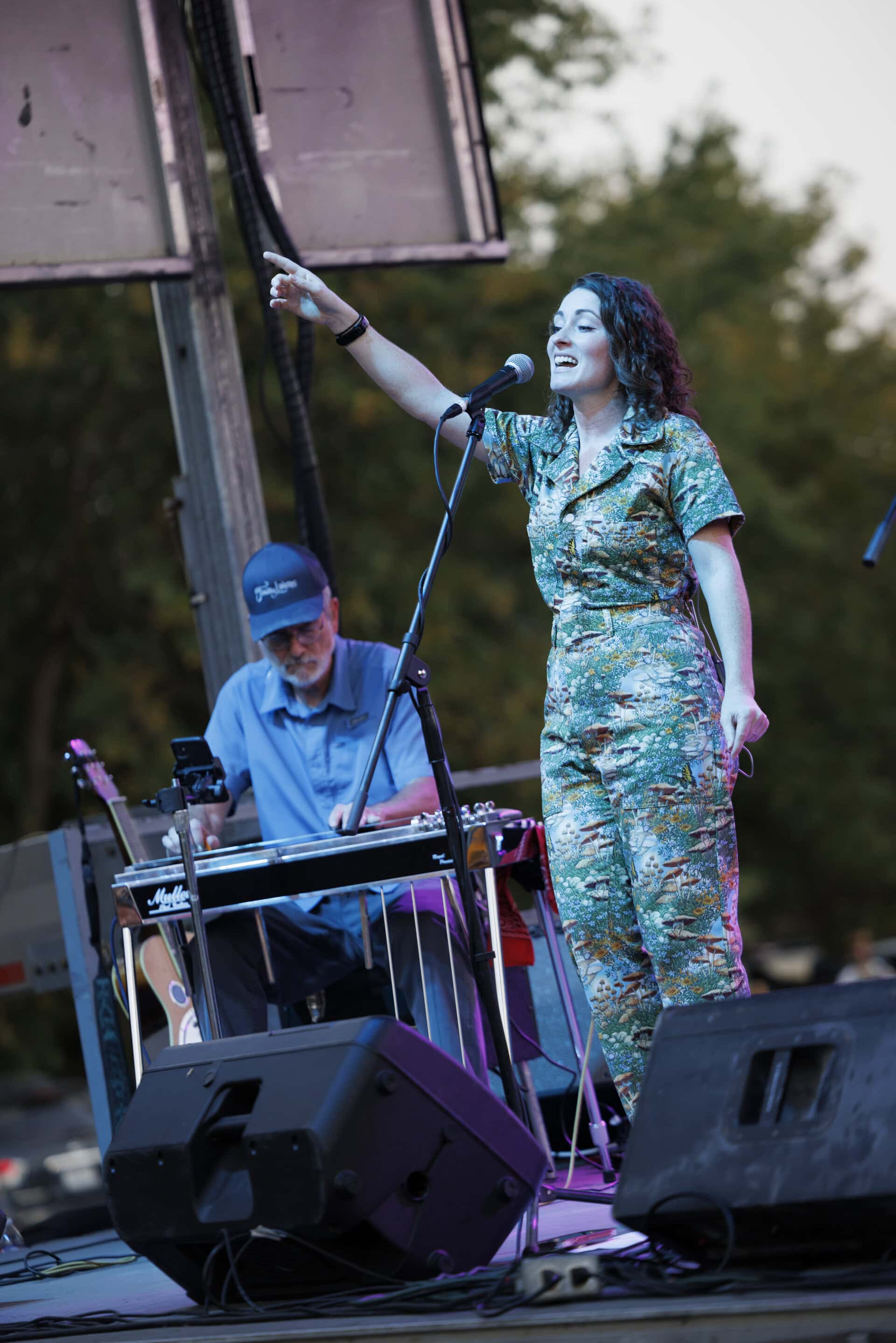 women singer standing on stage and man playing keyboard