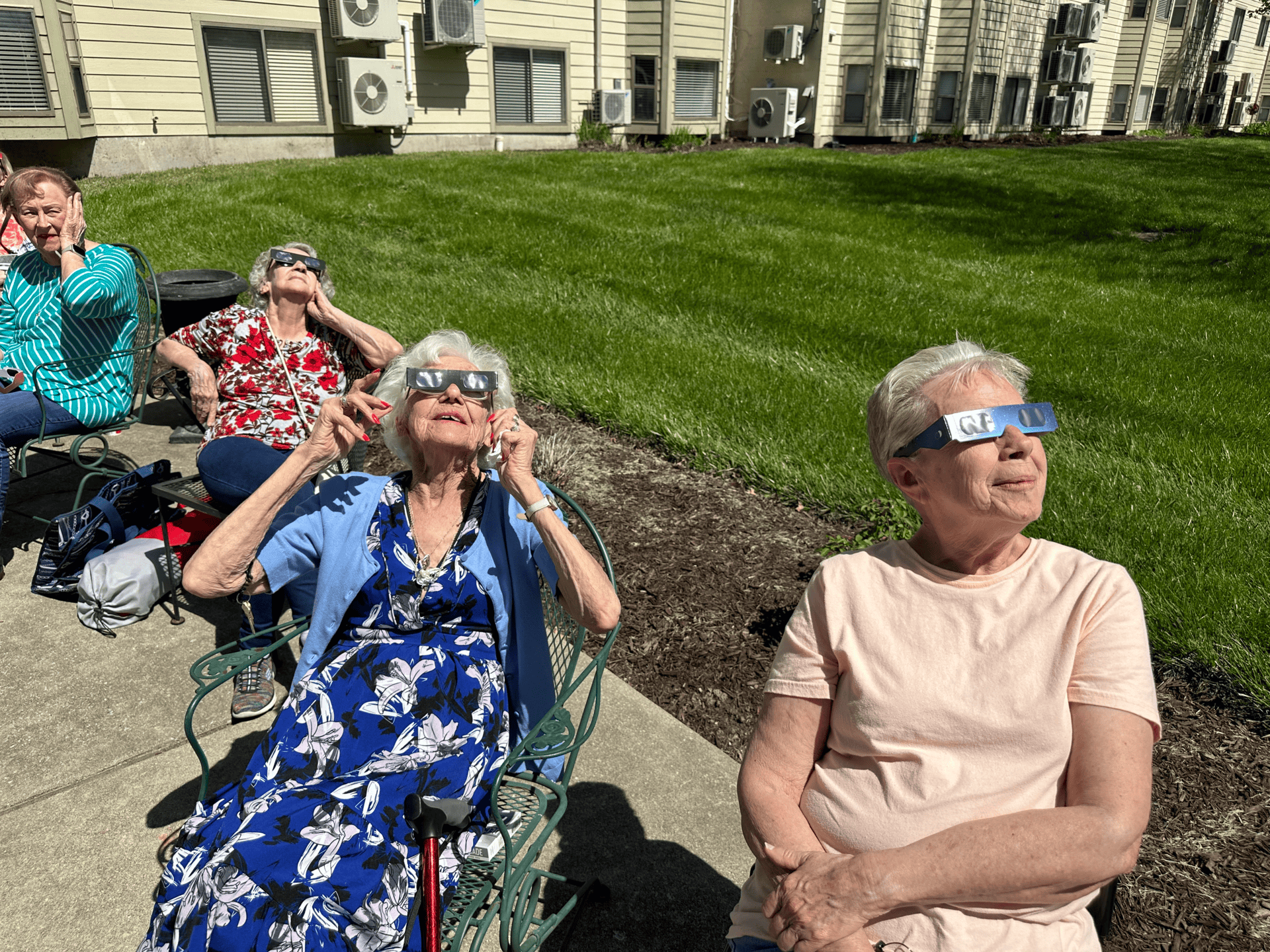 a group of seniors looking up at the sky during the 2024 solar eclipse watch party