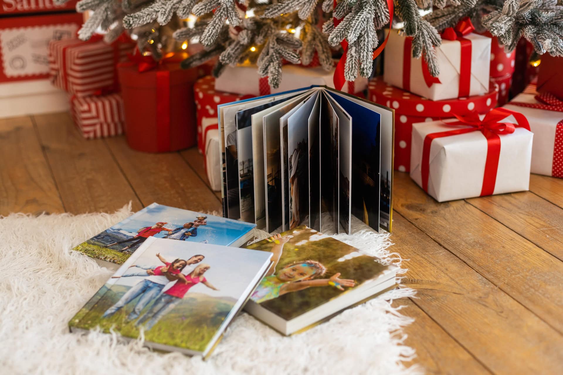 Family photo album and memory books sitting underneath Christmas tree